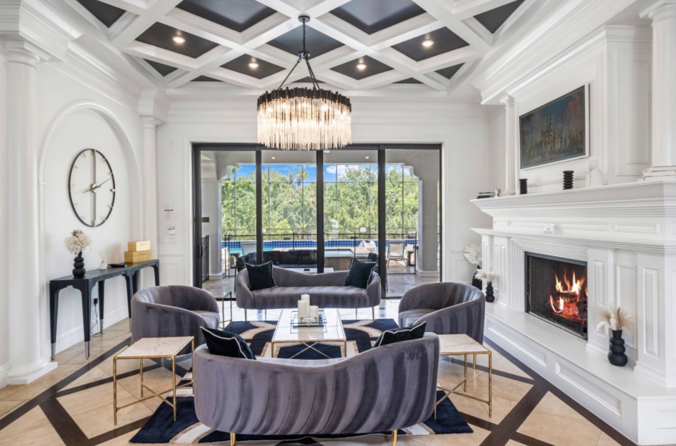Bright formal lounge with a fireplace and views toward the pool